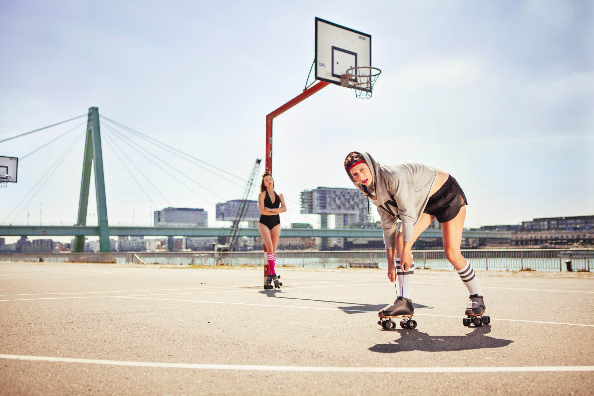 brainwheelz roller skates rollschuhe zwei frauen auf boden sitzend unter deutzer brücke