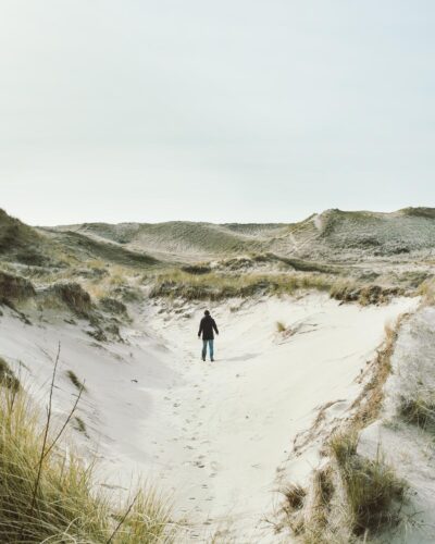 egmond aan zee mensch einsam alleine schwarze jackelandschaft dünen sand himmel niederlande urlaub